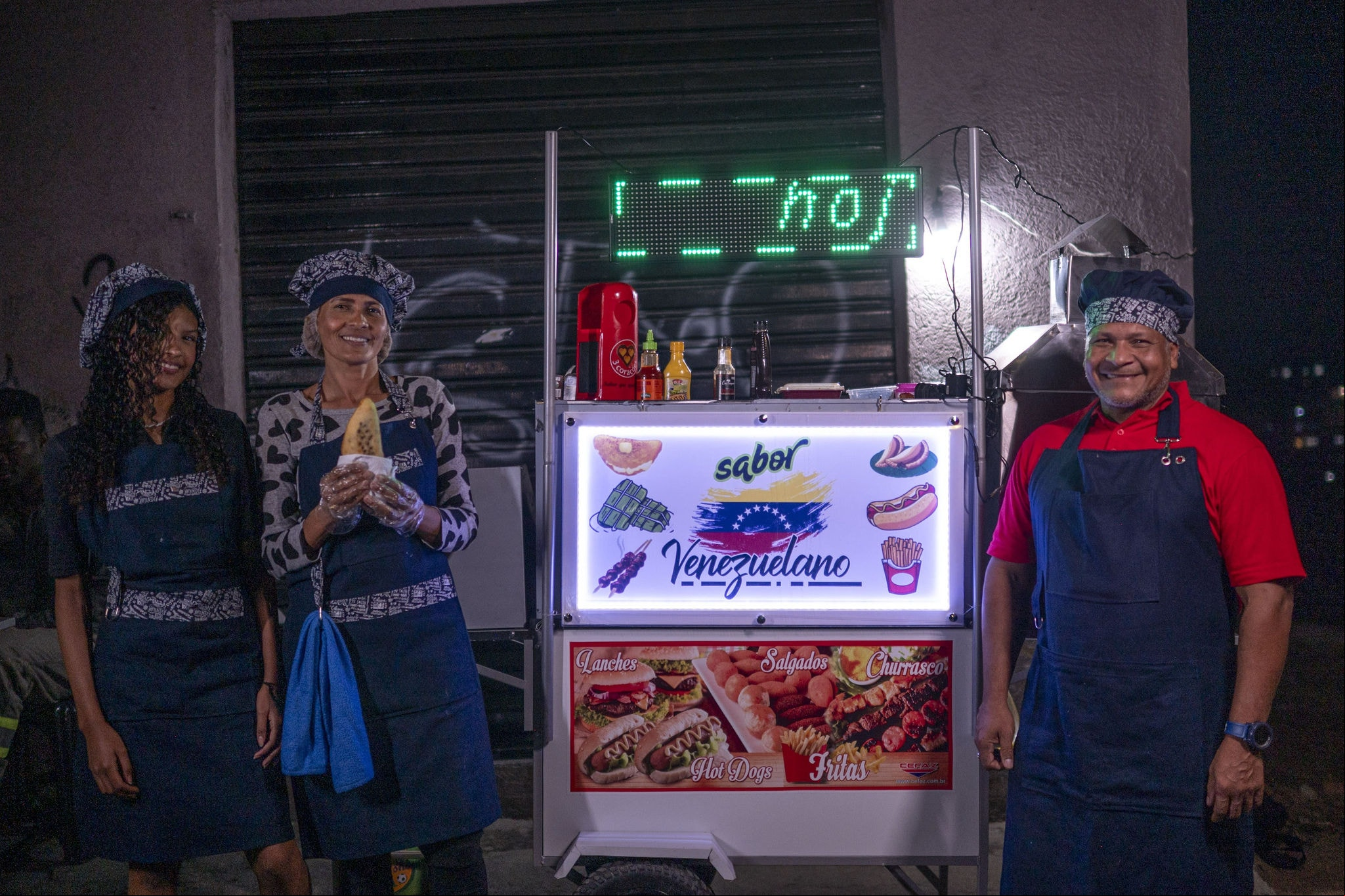 Família de venezuelanos vende empanadas e cachorro-quente em um carrinho no bairro Ouro Preto