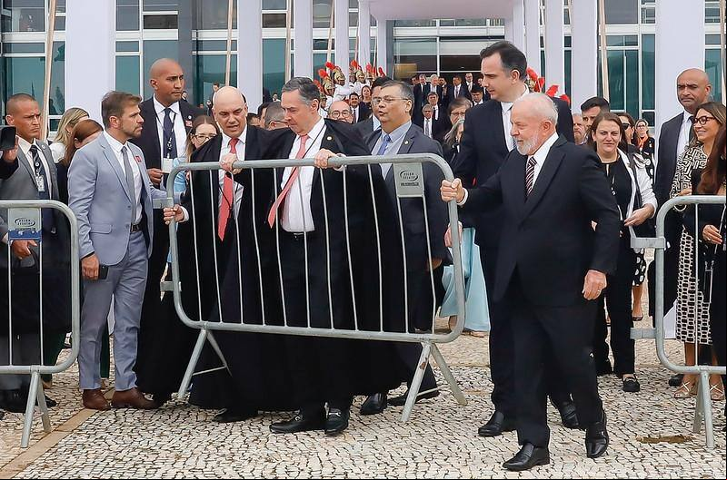Em meio à descontração que tomou conta do ato, os presidentes do STF, Luís Roberto Barroso, e da República, Lula, retiram últimas grades que isolavam o Palácio do Supremo da Praça dos Três Poderes